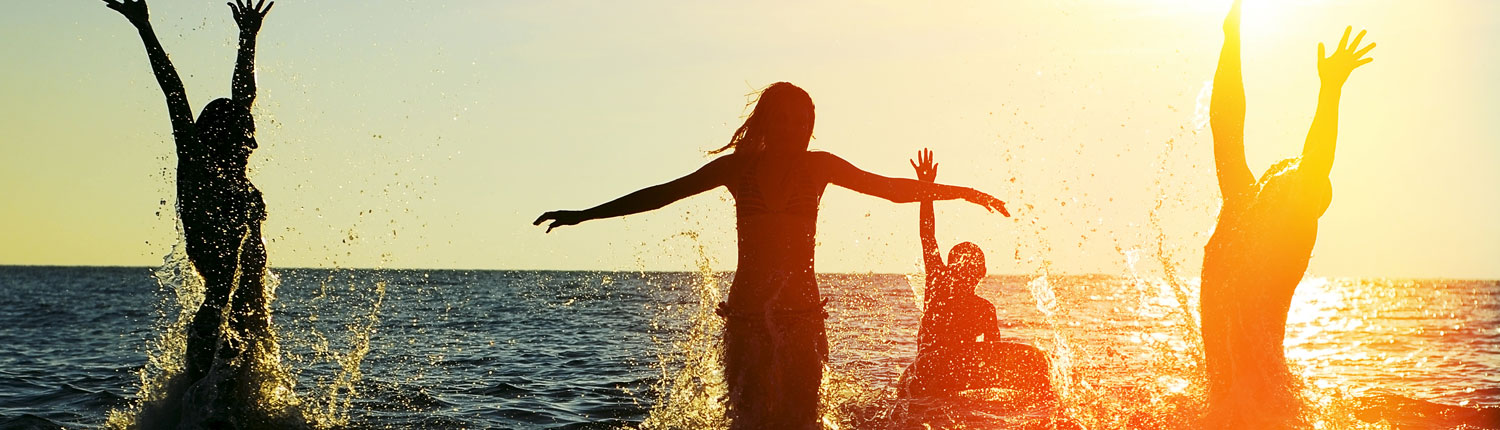 Young People Playing in the Ocean at Sunset